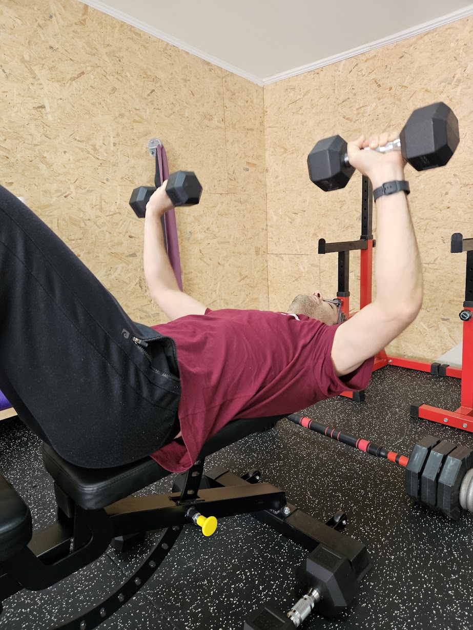 אדם מרים משקולות על ספסל